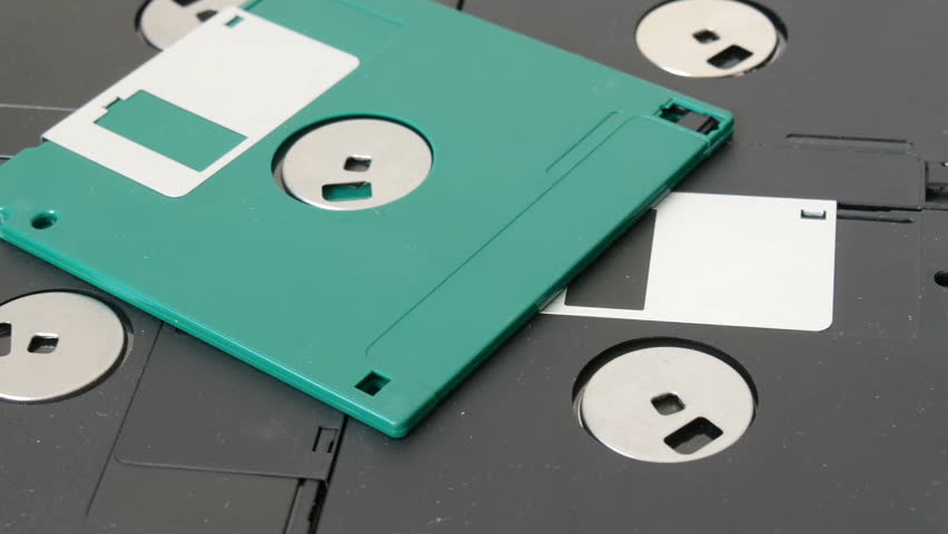 Close up view of many inch computer floppy disks or diskette scattered on a flat surface vintage technology.