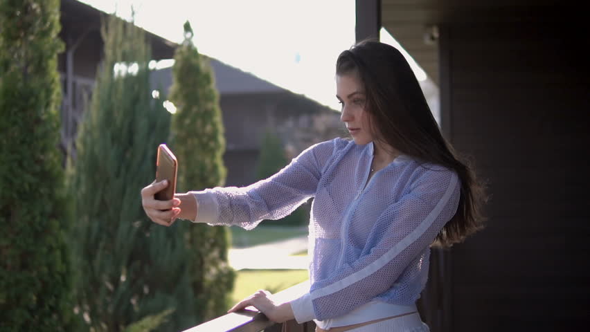 Pretty woman taking selfie photo with cellphone on terrace 