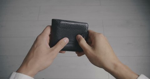 Close-up of a man's hand holding Leather Wallet Empty with No Money. The concept of poverty