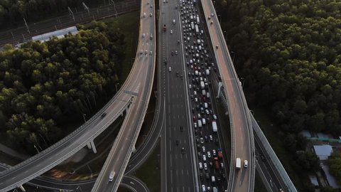Aerial view of a huge intersection with a lot of roads with nice sunset, sun shining in camera. Traffic jam on a 10 lanes highway part 2.