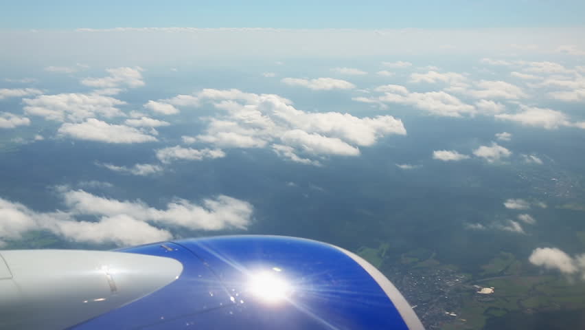 The plane is high in the sky, above the clouds. The engine of the aircraft from the window | Shutterstock HD Video #1016299663