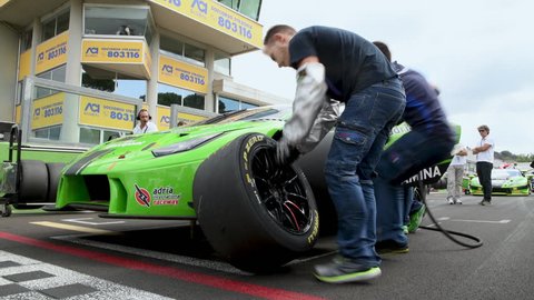Rome, Italy, september 8 2018. Low angle view of Lamborghini racing car on circuit starting grid, mechanics at work changing tire