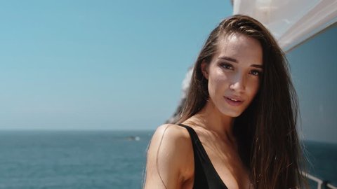 Sensual young woman in bikini on expensive private yacht in the ocean in slow motion