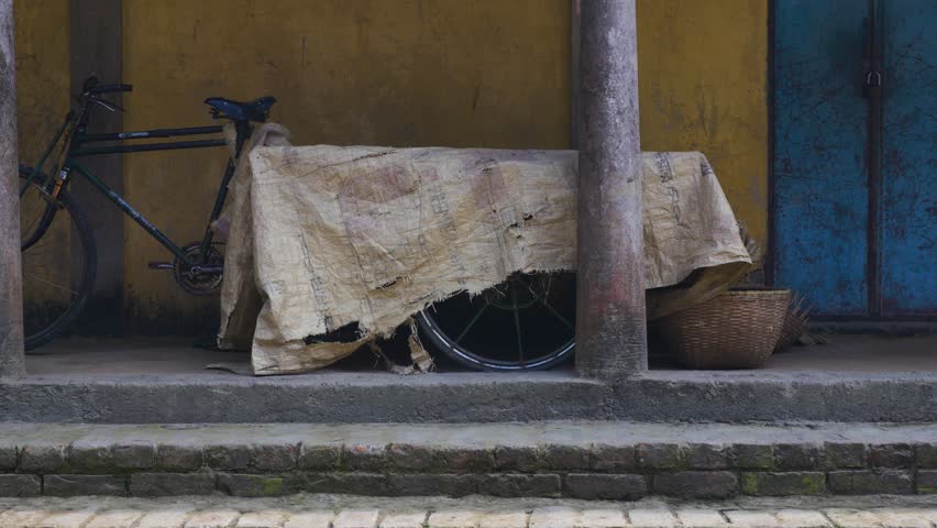 Bike with wagon trailer under covers in a village in Sylhet, Bangladesh