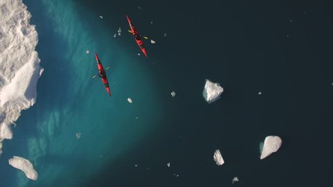 Greenland, aerials from kayaker paddling beneath icebergs