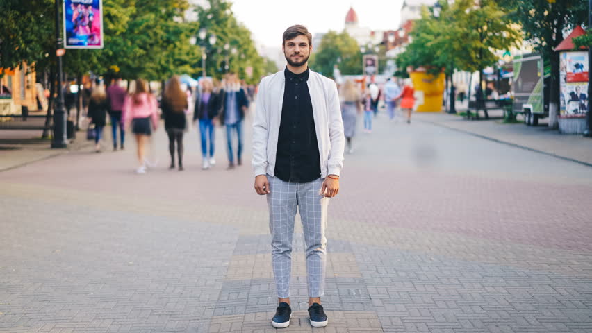 Time-lapse of handsome young man in stylish clothing standing in the street of big city and looking at camera with people moving around. Urban lifestyle and society concept. | Shutterstock HD Video #1016310265