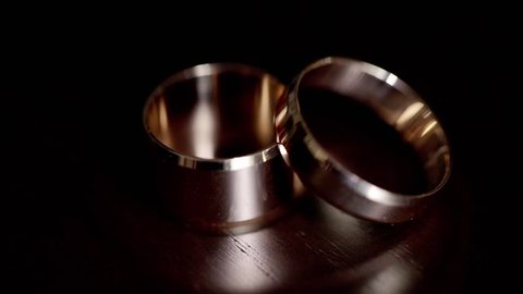 Wedding rings are not a dark table in the rays of light,two wedding rings in infinity sign. Love concept.