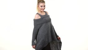 Happy blonde woman wearing fashionable grey long sleeve cold shoulder jumper woolen sweater, attractive model presenting clothing moves for camera on white - Powered by Shutterstock - Get 15% off with code: PIKWIZARD15