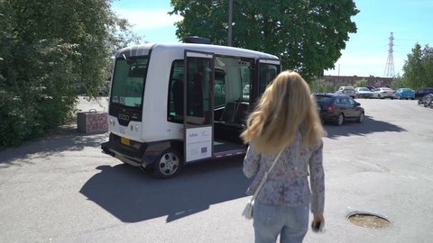 HELSINKI, FINLAND - MAY 25, 2018: Young woman in automated remotely operated bus in Helsinki. Unmanned public transport on street.