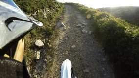 Enduro riding POV on mountain trails on a sunny day.