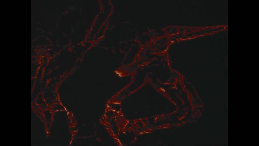 CIRCA 1973 - Close-ups show lava flowing through the Pauahi Crater at nighttime.