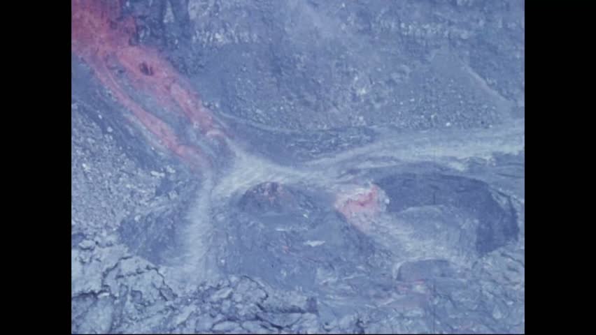 CIRCA 1973 - Lava pours through crevices in the Pauahi Crater.