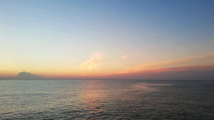 A beautiful sunrise in the Mediterranean sea. The light of sun reflects in the water and creating intense colors. The video was taken from a beach in the town of Cullera, in Valencia, Spain, Europe.