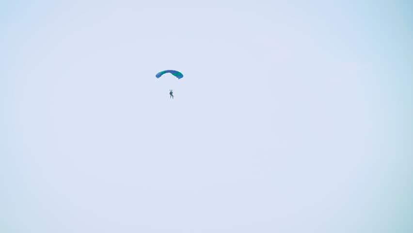 a parachute and a man in the sky.