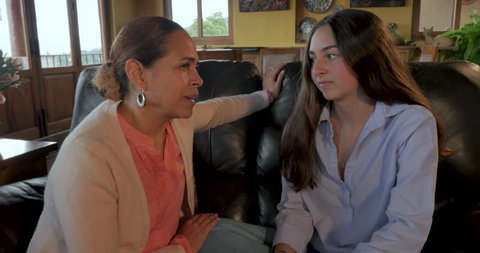 Mexican mom talking to her teenage daughter giving her advice and sharing her wisdom - gimbal shot