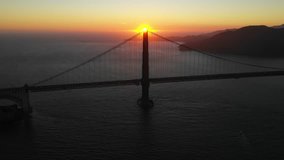 Sun setting behind the famous Golden Gate Bridge, San Francisco, California, USA