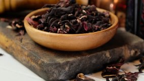 Dried hibiscus loose tea leaves in wooden bowl