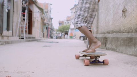 Child Skateboards Through Favela Slow Motion