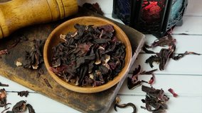 Dried loose hibiscus tea leaves in wooden bowl