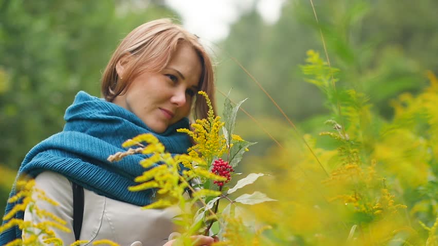 Portrait of a young beautiful woman enjoying autumn in the park