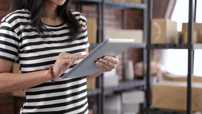 close up of woman with tablet pc in front of product shelf