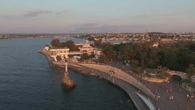 Summer. Evening. Sunset. Shooting from the air of  Sevastopol bay, Seaside boulevard, promenade, Monument to the sunken ships. overflight from the sea