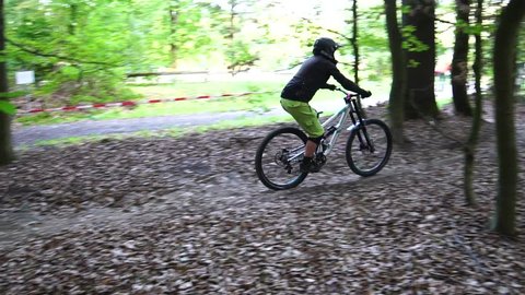 A Young Man Riding Bike In The Bike Park. Sport Background. Beautiful Green Landscape With Forest. Slow Motion And Close Up.