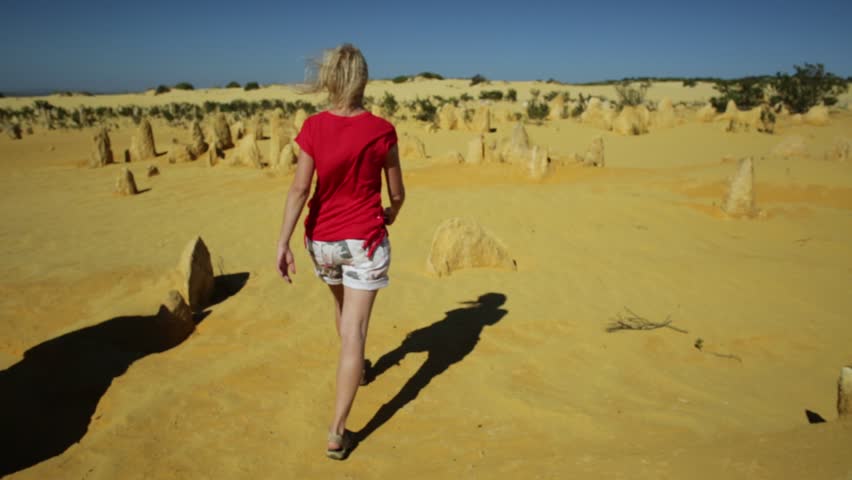 Western Australia travel freedom concept. Carefree woman walking the desert of Pinnacles limestone in Nambung National Park of Cervantes, in WA state of Australia