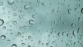 water droplets on the glass of window on the background of rainy dark clouds and sky
