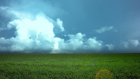 Green field and cloudy sky. Time lapse. Wide angle
