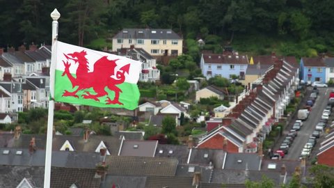 Welsh flag blowing in the wind above the Mumbles area in Swansea