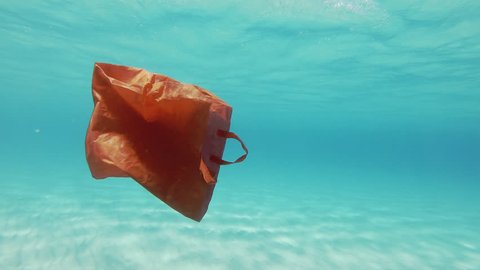Plastic Pollution Underwater. Red Plastic Shopping Bag Floating Underwater In The Mediterranean Sea