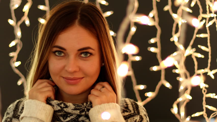 Close up of a cute women in front of Christmas lights.