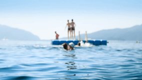 4k out of focus video of people relaxing on floating pantoon in the sea