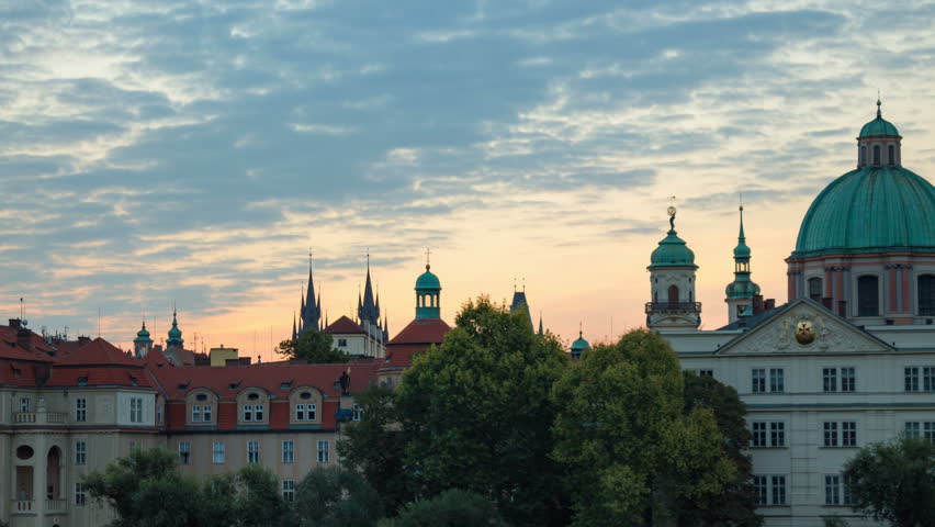 Footage of city Praha with buildings silhouette on horizon. Summertime sunrise timelapse. Panoramic view of spires, domes and gothic roofs. Famous and beautiful european city. Czech Republic