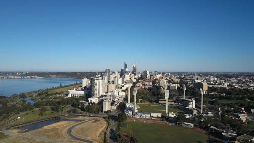 Aerial view of drone flight above Swan River with pan between the shores of South Perth and the scenic skyline panorama of Perth city, capital of Western Australia.