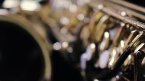Details of a golden saxophone. A wind instrument seen very close to the camera.