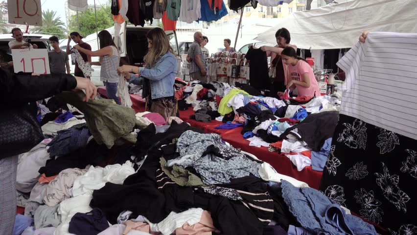 Antalya, Turkey-May,14,2018. Turkish flea market. Sale of textiles, clothing and footwear. Men and women are rummaging in piles of clothes.