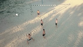 Sport Soccer players in dynamic action funny play on the sand in beach football in summer sunny day under sunlight. Aerial View, Drone 4K Video
