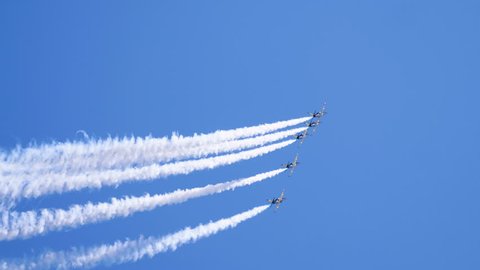 Five airplanes flying on the background of blue sky and leaving a condensation trail. 4K