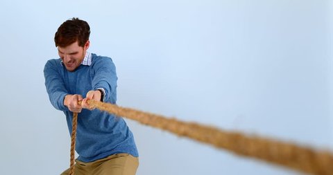 Man pulling a rope tug of war against blue background 4k