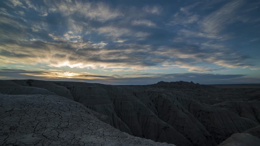 Morning, sunrise time lapse of the clouds, panning over the rugged landscape of Badlands National Park, in South Dakota