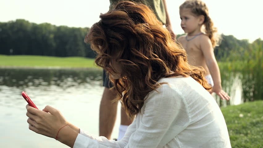Father talking and playing with his daughter, while mother texting smartphone and chating. Family problems. Family crisis. Steadycam shot.