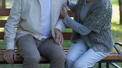Caring wife calming her old husband, problems with lower back, pinched nerves