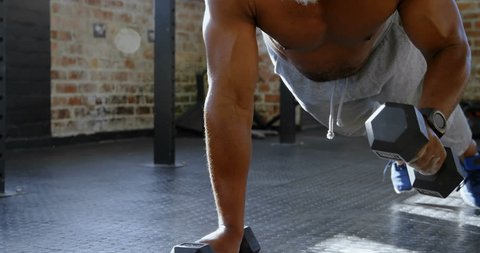 Senior man doing push ups with dumbbells in the fitness studio 4k Video de stock