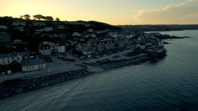 Drone rises slowly by the Cornish town of Marazion to reveal sunrise. Shot from public land