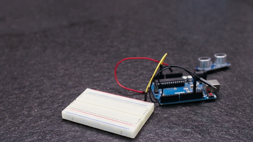 construction of an interactive circuit with an open source microcontroller, a proximity sensor and a prototyping base with cables. Preparation of a prototype interaction design before programming Royalty-Free Stock Footage #1016459806
