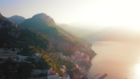 A view of the picturesque landscape of Atrani with the sun shining on the background