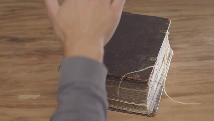 A man's palm on a old book, an oath on the bible. Top view from above Royalty-Free Stock Footage #1016467315