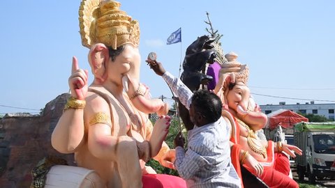 AMRAVATI, MAHARASHTRA - SEPTEMBER 12, 2018: Artist gives finishing touches on an idol of the Hindu god Lord Ganesha at an artist's workshop for Ganesha festival.